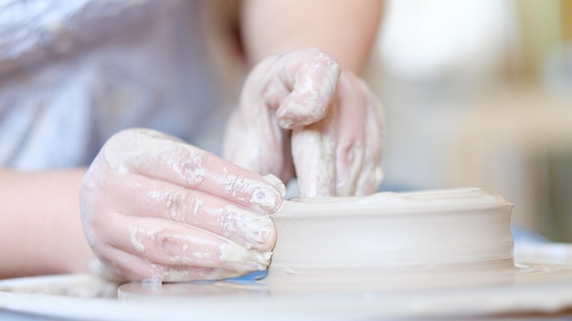 Artisanat de poterie mains de passe-temps formant et façonnant l'argile sur la roue de potier