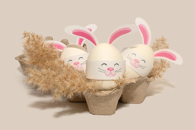Artisanat pour enfants pour Pâques à partir d'œufs Lapins avec oreilles dans une boîte Sur fond gris Fête religieuse