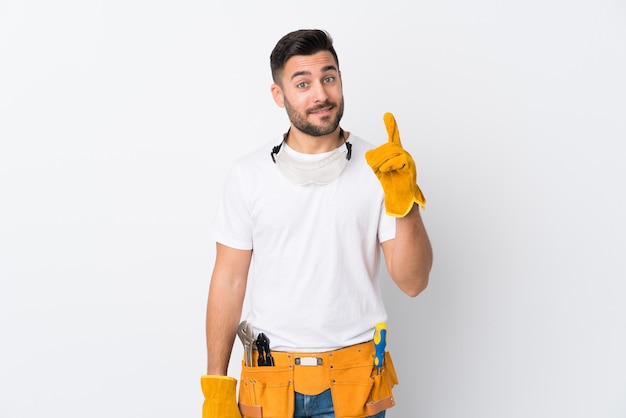 Artisans ou électricien homme sur mur blanc isolé pointant avec l'index une excellente idée