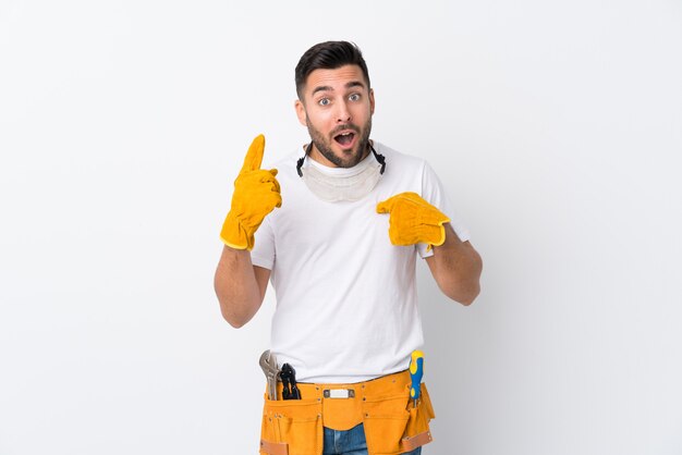 Artisans ou électricien sur un mur blanc isolé avec une expression faciale surprise