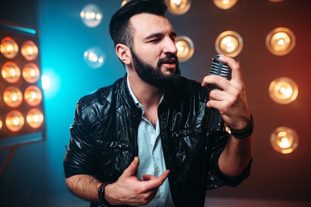 Artiste barbu avec microphone chanter une chanson