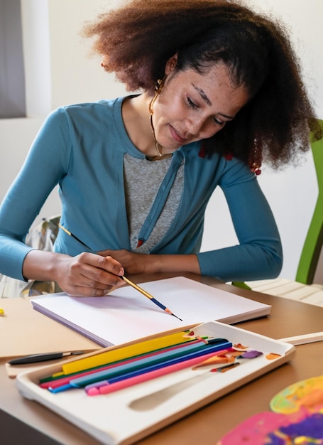 Un artiste avec un carnet de croquis et des crayons créant des chefs-d'œuvre colorés