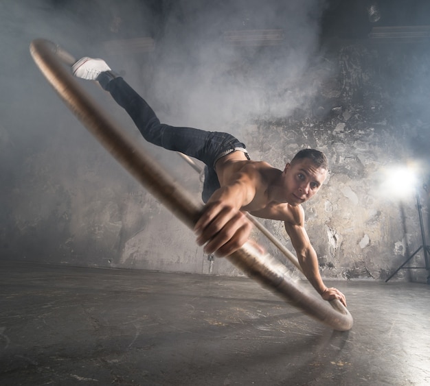 Artiste de cirque fort faisant tourner une roue cyr