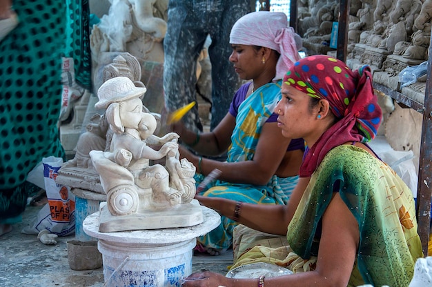 L'artiste donne la touche finale à une idole du dieu hindou Lord Ganesha lors d'un atelier d'artiste pour le festival Ganesha