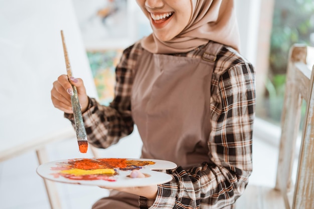 Artiste féminine musulmane peignant sur toile au home studio