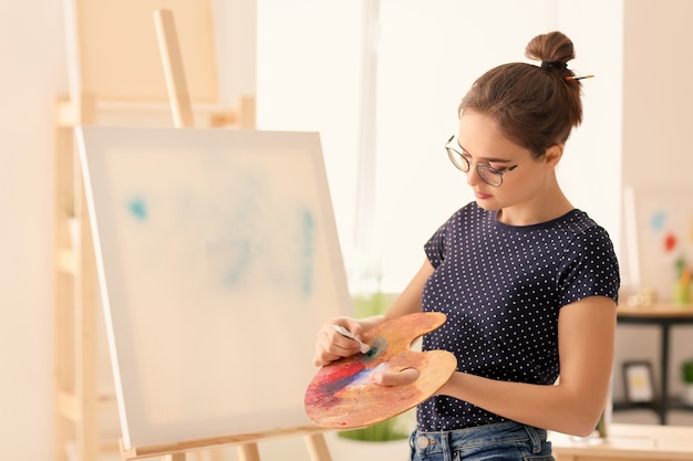 Artiste féminine avec palette et peinture en atelier