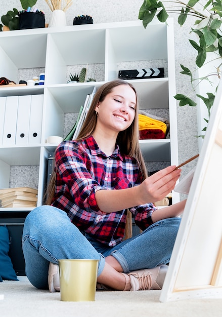 Artiste féminine peignant à la maison