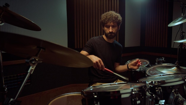 Artiste frappant des cymbales de batterie en studio Batteur jouant en solo dans une salle de concert