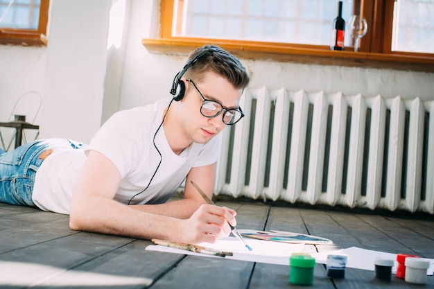 Artiste de jeune homme peint une image