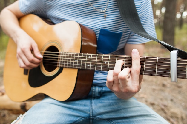 artiste jouant de la guitare en forêt. barde randonnée et mode de vie des voyageurs