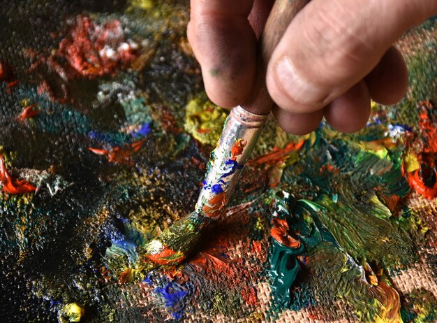 Artiste mélangeant la peinture à l'huile de couleur sur la palette