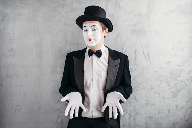 Artiste mime masculin drôle avec du maquillage dans des gants et un chapeau.