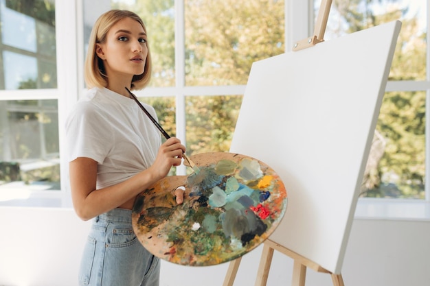 L'artiste peint en studio Jolie fille portant un t-shirt blanc