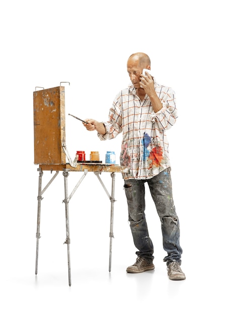 Artiste, peintre au travail isolé sur fond blanc studio