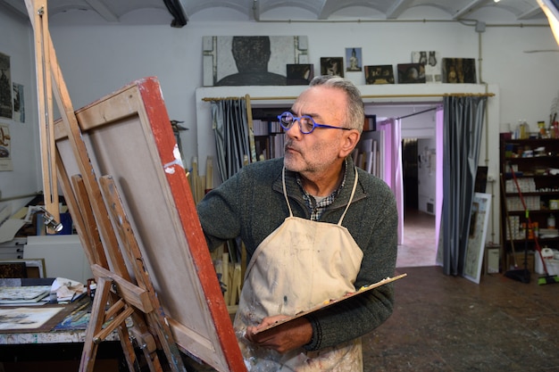 Artiste peintre en train de peindre un tableau en studio