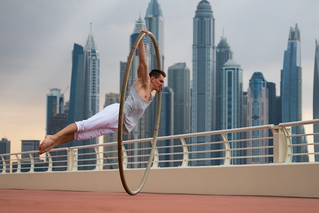 Artiste de la roue Cyr avec fond de paysage urbain de Dubaï