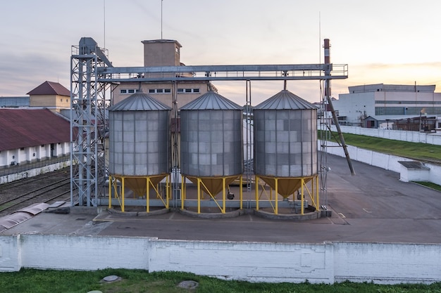 Ascenseur de grenier moderne avec silos d'argent sur l'agro-industrie et l'usine de fabrication pour le traitement, le séchage, le nettoyage et le stockage des produits agricoles farine céréales et céréales