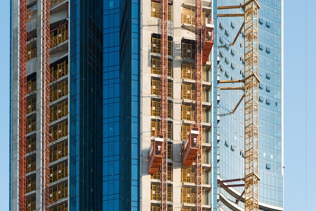 Photo ascenseur de levage de passagers utilisé pour lever des ouvriers et du matériel sur le chantier de construction.