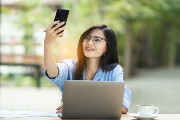 Asia Woman travaille sur l'ordinateur personnel et le smartphone sur Internet à domicile