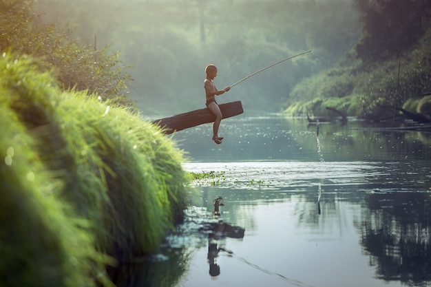 Asian Boy pêchant à la rivière