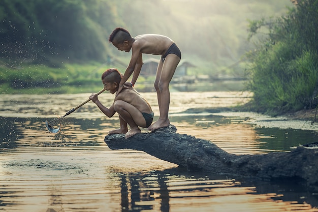 Asian Boy pêchant à la rivière