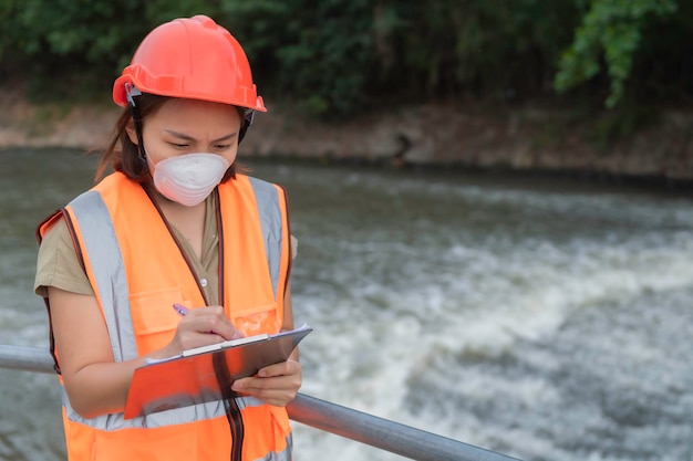 Asian Female engineering travaillant xA à l'usine de traitement des eaux uséesBiologiste marin analysant les résultats des tests d'eauConcept de la journée mondiale de l'environnement