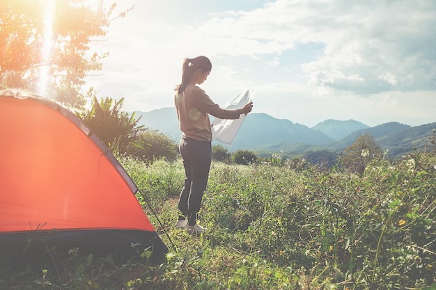 Asian hipster jolie fille adolescent jouissant du lever du soleil à l&#39;extérieur de la tente. camping en forêt