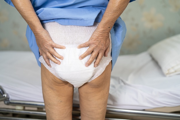 Asian senior woman patient portant une couche d'incontinence à l'hôpital