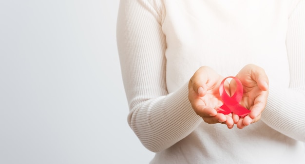 Asian woman holding ruban rose de sensibilisation au cancer du sein sur la charité de traitement des mains