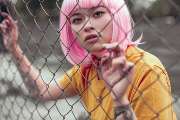 Asiatique adolescent fille toucher net clôture