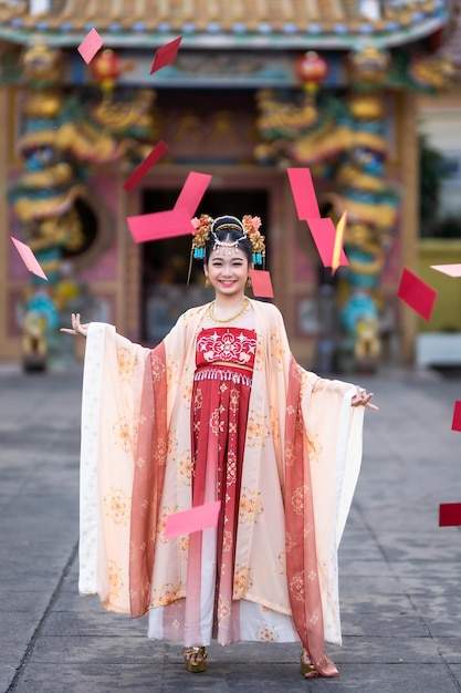 Asiatique Bonne beauté petite fille portant des costumes anciens chinois avec de nombreuses décorations d'enveloppes rouges dispersées pour le festival du nouvel an chinois célèbrent la culture de la Chine au sanctuaire chinois en Thaïlande