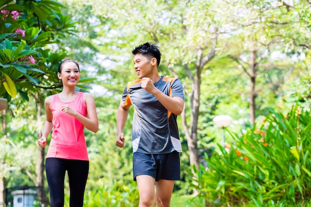 Asiatique chinois homme et femme jogging dans le parc de la ville