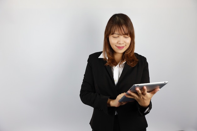 Asiatique Femme d'affaires à l'aide de tablette avec un visage souriant et confiant sur blanc