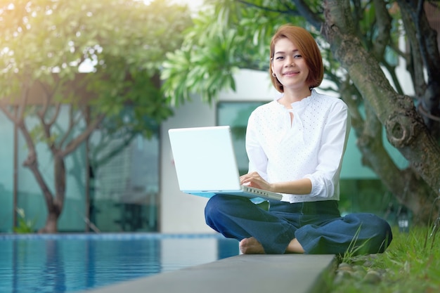 Asiatique femme assise à utiliser un ordinateur portable au parc