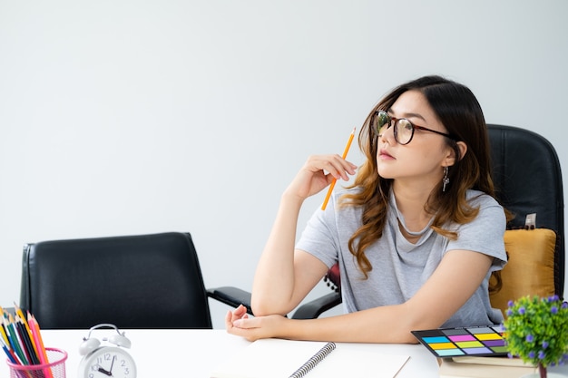 Asiatique Femme Aux Longs Cheveux Dorés, Portant Des Lunettes, Assis Au Bureau