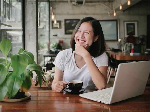 Asiatique femme buvant du café et se détendre dans un café