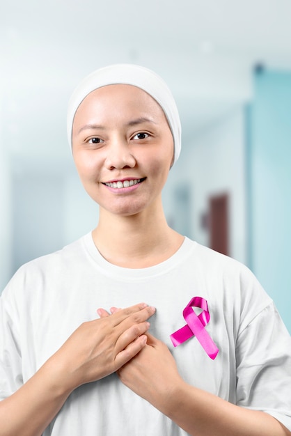 Photo asiatique femme dans une chemise blanche avec un ruban rose à l'hôpital