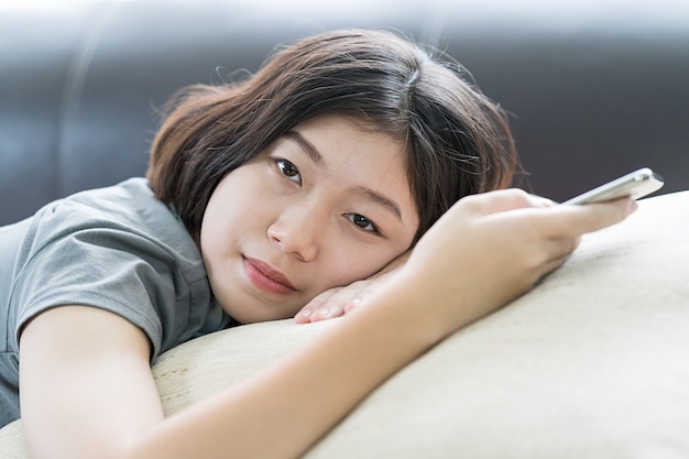 Asiatique femme écoutant de la musique depuis un téléphone mobile