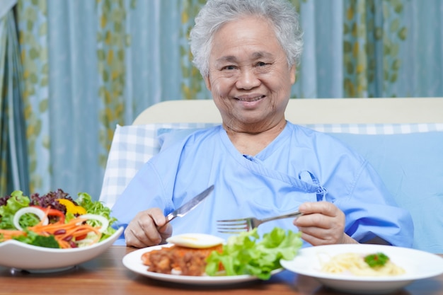 Asiatique femme senior patient manger le petit déjeuner à l'hôpital.