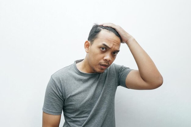 Photo un asiatique frustré par sa calvitie et sa chute de cheveux
