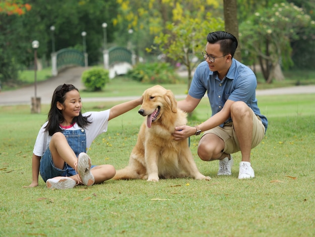 Asiatique homme et fille avec chien golden retriever dans le parc