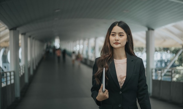 Asiatique jeune belle femme d'affaires marchant en plein air