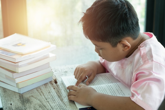 Un Asiatique a lu un livre à la maison. concept d&#39;éducation