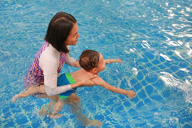 Asiatique mère enseignant bébé garçon dans la piscine