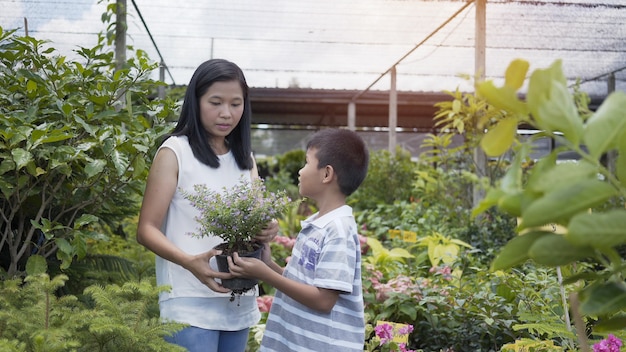 Asiatique mère et son fils s&#39;occupent des arbres dans le jardin.