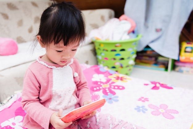 Asiatique mignon petit enfant jouant au-dessus du lit dans une matinée détendue