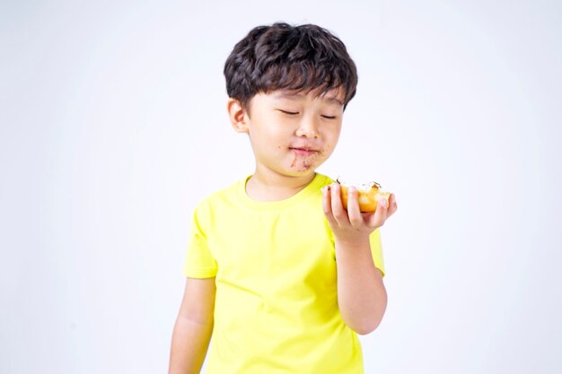 Asiatique petit garçon mignon mangeant un gros beignet