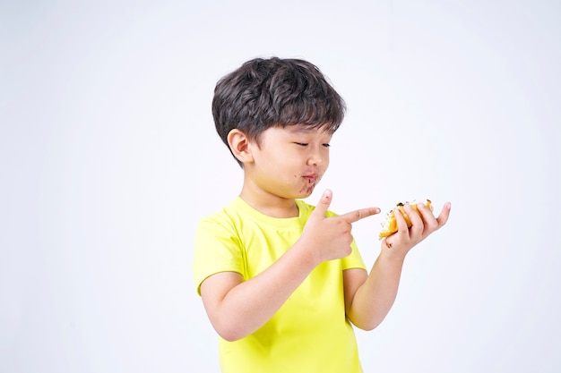 Asiatique petit garçon mignon mangeant un gros beignet
