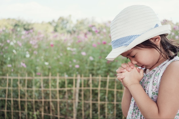 Asiatique petite fille priant, concept de foi de christianisme