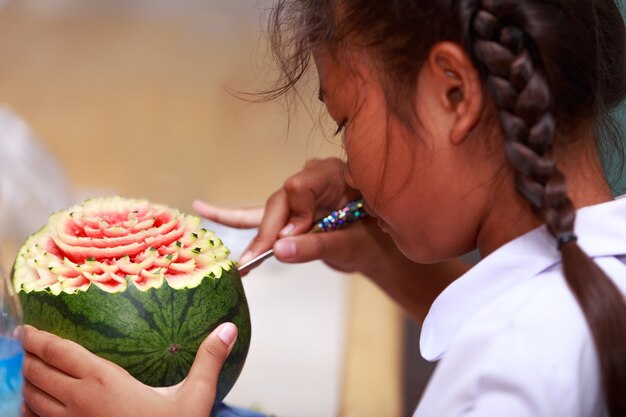 Asiatique petite fille sculpter des fruits à l&#39;école